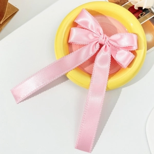 Pince à cheveux élégante en satin rose avec nœud à bords festonnés et long ruban soyeux