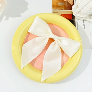 Detailed macro view of the double-layered cream white satin ribbon bow hair clip texture