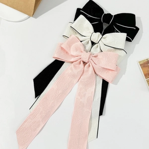 Elegant bow hair clips with long ribbons in black, white, and pink jacquard fabric
