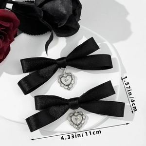 Detail view of black satin bow hair clips with silver heart cross charms and size measurements