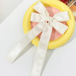 Barrette à nœud en satin blanc crème avec rubans sur une assiette décorative élégante