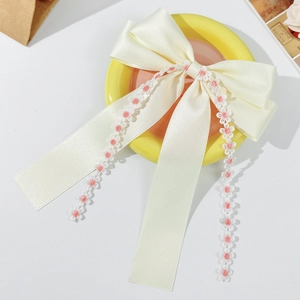 Elegant cream satin bow hair clip featuring delicate embroidered white flower tassels
