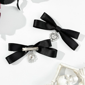 Gothic black satin bow hair clips with silver heart and cross charms on white background
