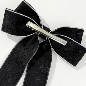 Detailed back view of vintage black bow hair clip with lace texture and metal alligator clip