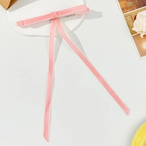 Detailed view of the pink velvet long ribbon bow hair clip with soft fabric texture