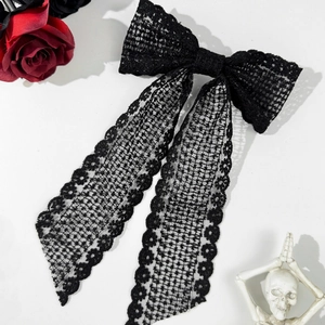 Detailed view of black lace bow hair clip with elegant floral streamers in gothic style
