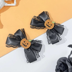 Detail view of Halloween bow hair clips with black lace and sparkly orange pumpkin motifs