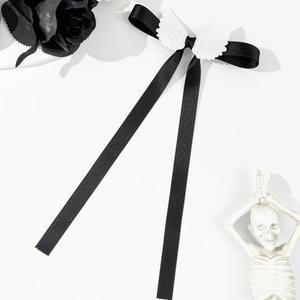 Détail d'un nœud en satin noir avec des ailes d'ange blanches et de longs rubans