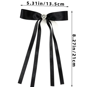 Detail view of black satin bow hair clip with rhinestone heart and long ribbons