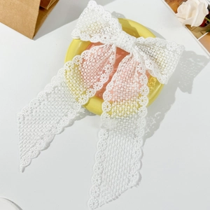 Elegant white lace bow hair clip with long streamers and floral embroidery texture