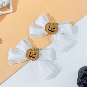 Detail view of Halloween bow hair clip featuring a glittery orange pumpkin on white lace