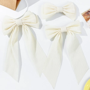 Elegant cream bow hair clip set with pleated ribbons on a minimalist white background