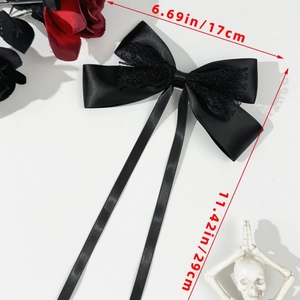 Detail of elegant black satin bow hair clip with lace center and long 29cm silk ribbons