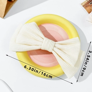 Detail view of the cream pleated bow hair clip showing dimensions of 16cm by 9cm