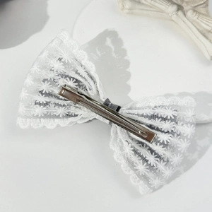 Detailed back view of a lace bow hair clip featuring embroidery and a silver metal alligator clip