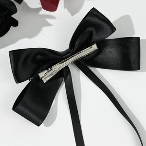 Close-up of black satin ribbon bow hair clip with silver metal duckbill clip back