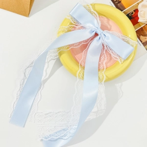 Sweet light blue satin bow hair clip with white lace trim for women on a yellow plate