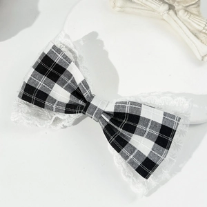Close-up of vintage houndstooth bow hair clip with elegant white lace embroidery edges