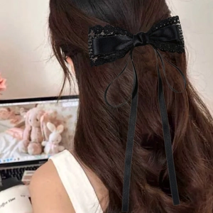 Gros plan sur le nœud en dentelle noire avec de longs rubans portés sur les cheveux