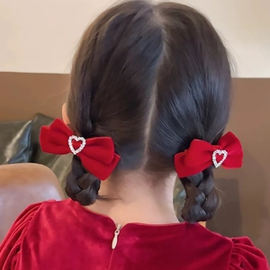 Red velvet heart bow hair clips shown on a young girl's braided hair for a sweet look