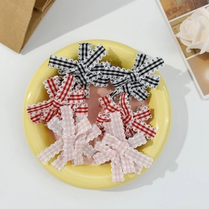 Sweet plaid bow hair clips in black red and pink arranged in a ceramic dish