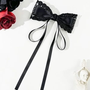 Détail d'un élégant nœud à cheveux en dentelle noire avec rubans au style gothique chic