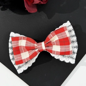 Close-up of red houndstooth bow hair clip with vintage white lace floral embroidery