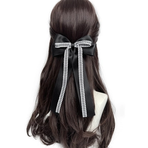 Détail de la pince à cheveux en satin noir vintage avec ruban pied-de-poule et dentelle