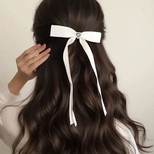 White satin ribbon bow hair clip with heart rhinestone on brunette hair