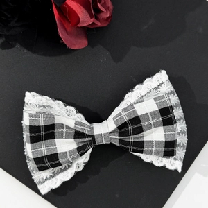 Vintage houndstooth bow hair clip with white lace trim and elegant black and white pattern