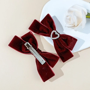 Detail view of burgundy velvet bow hair clips with heart rhinestone and metal duckbill clip