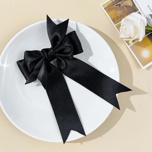 Barrette à cheveux élégante en satin noir à double couche sur une assiette en céramique