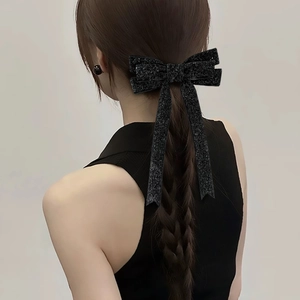Elegant black oversized sequin bow hair clip with streamers for a stylish ponytail look