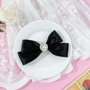 Sweet black satin bow hair clip featuring a sparkling rhinestone heart and pearl center