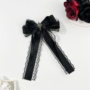 Gothic black satin bow hair clip with lace trim and vintage gemstone on white background