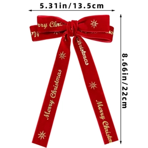 Detail view of red velvet Christmas bow hair clip with gold Merry Christmas lettering