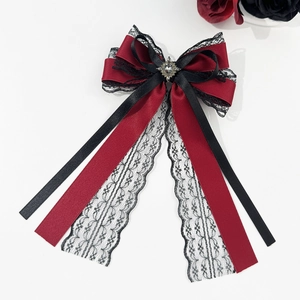 Detail of Gothic dark red satin bow with black lace and vintage metal rhinestone center