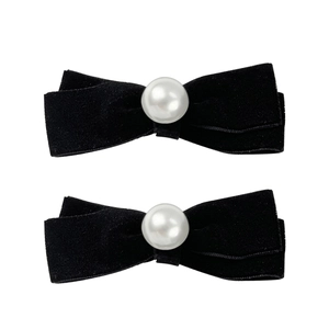 Elegant pair of black velvet bow hair clips with central pearl accents on white background