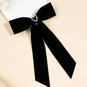 Détail du nœud à cheveux en velours noir avec strass cœur et longs rubans pendants