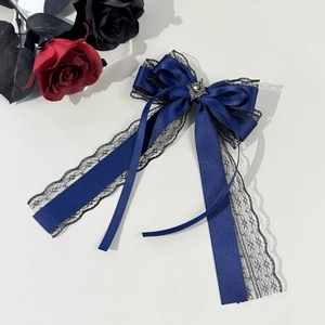 Detail of dark blue satin bow hair clip with black lace trim and vintage silver gem