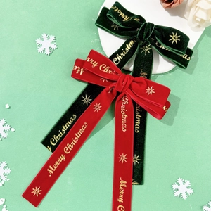 Detail of red and green velvet Christmas hair clips with gold Merry Christmas lettering