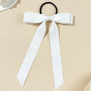 Close-up of white satin ribbon bow hair tie with long streamers and elastic band