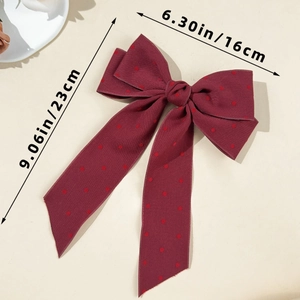 Detailed view of burgundy polka dot bow hair clip showing 16cm width and 23cm length dimensions