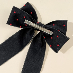 Detailed back view of polka dot bow hair clip showing the silver metal alligator clip