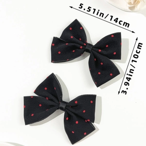 Detail view showing a pair of large black and red polka dot bow hair clips 14cm in size