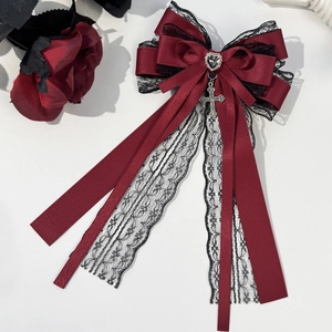 Detail of gothic lolita bow hair clip with dark red lace, heart gem and cross pendant