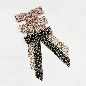 Three leopard print bow hair clips in pink, beige and black colors with long ribbons