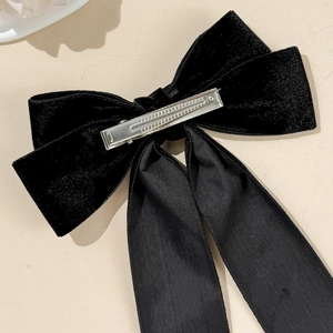 Close-up of black velvet bow hair clip with silver metal alligator clasp detail