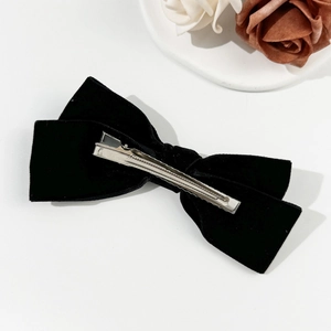 Close-up detail of a vintage black velvet bow hair clip with a durable silver metal base