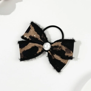 Detailed view of leopard print bow hair scrunchie with a central white imitation pearl